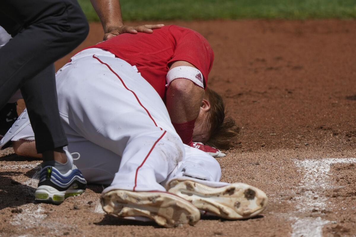 Boston Red Sox third baseman Justin Turner rolls on the ground after being hit in the face on a pitch.