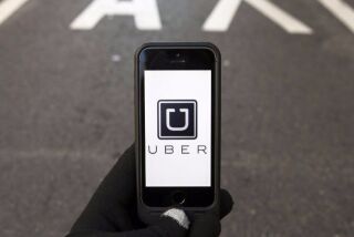 The logo of car-sharing service app Uber on a smartphone over a reserved lane for taxis in a street is seen in this file photo illustration taken in Madrid on Dec. 10, 2014.