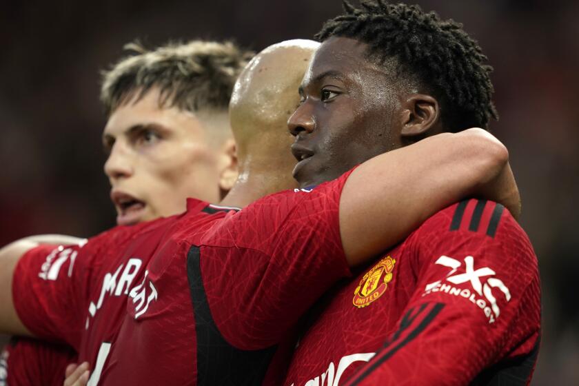 Manchester United's Kobbie Mainoo celebrates with teammates after scoring his side's opening goal during the English Premier League soccer match between Manchester United and Newcastle United, in Manchester, England, Wednesday, May 15, 2024. (AP Photo/Dave Thompson)