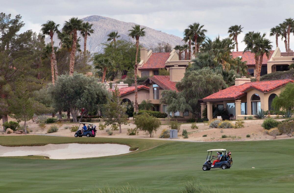 Golfers ride by upscale homes along a fairway at Rams Hill Golf Course. There are five golf courses in the area. — Charlie Neuman