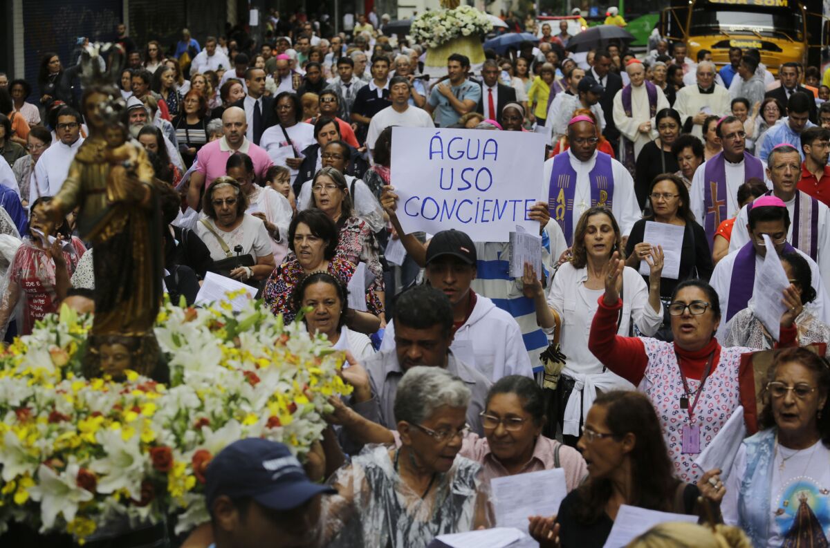 People, praying for more rain, take part in a religious procession, carrying statues of their city's patron saint, Our Lady of Penha, through the streets of Sao Paulo on March 22.