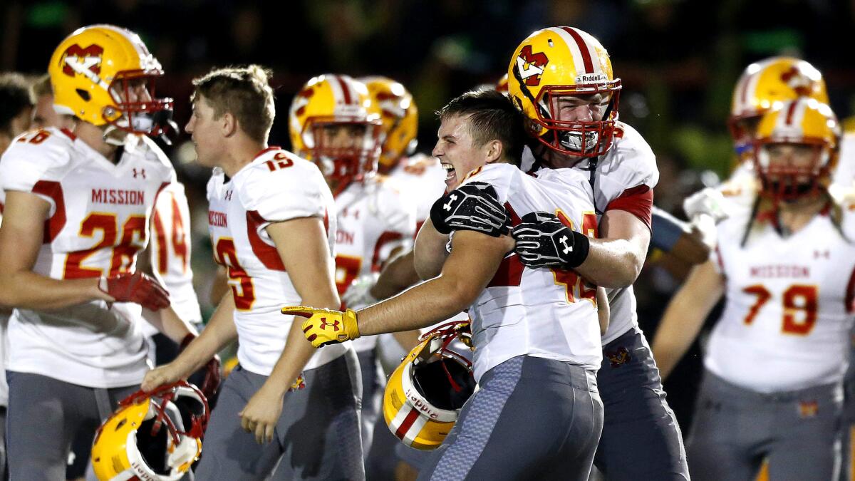 Mission Viejo teammates Mitch Dossey (43), left, and Jack Muench (85) celebrate after the Diablos' 12-7 defeat of Long Beach Poly on Friday night at Veterans Stadium.