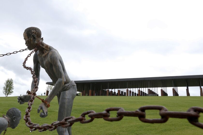 A statue of a chained man is on display at the National Memorial for Peace and Justice, a new memorial to honor thousands of people killed in racist lynchings, Sunday, April 22, 2018, in Montgomery, Ala. The national memorial aims to teach about America's past in hope of promoting understanding and healing. It's scheduled to open on Thursday. (AP Photo/Brynn Anderson)