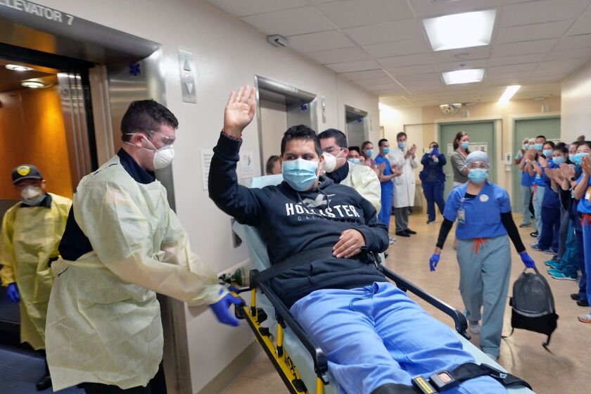 Medical workers clap as patient Juan Valdez Cazares as he leaves UC San Diego Medical Center in Hillcrest. (Photo by Kyle Dykes, UC San Diego Health)