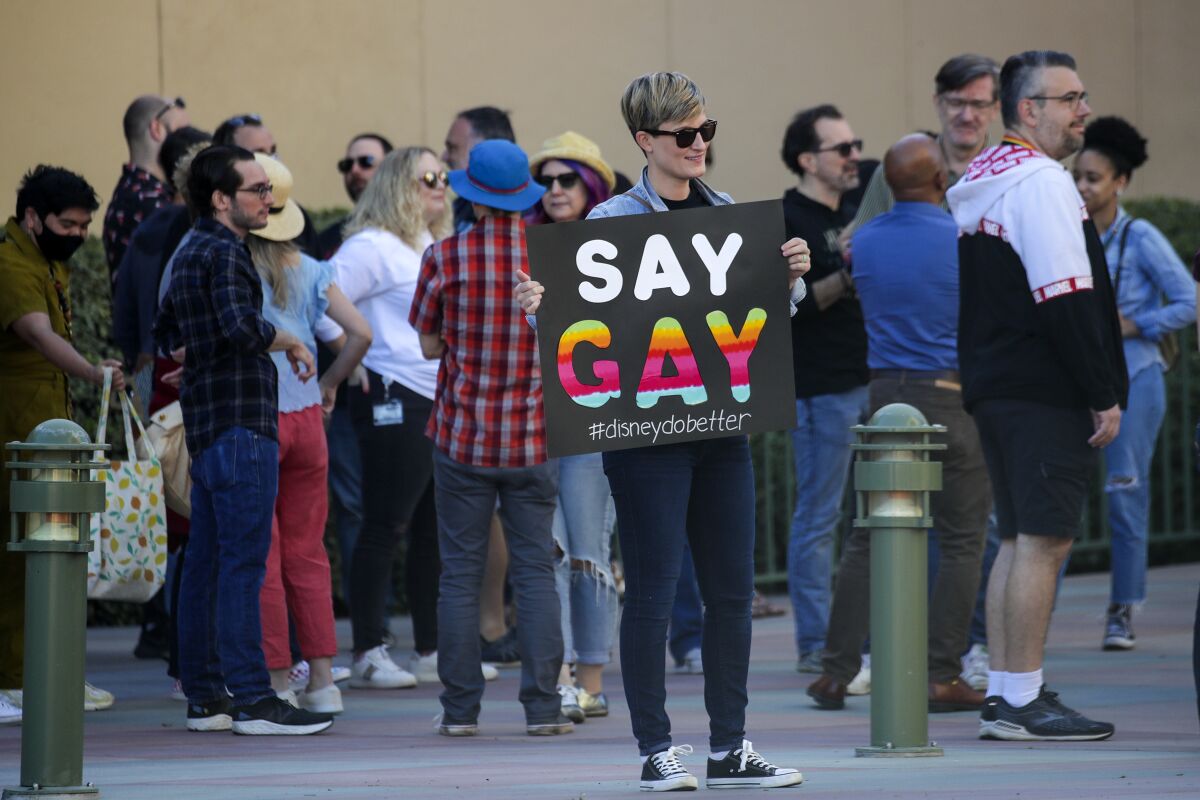 Disney employees protest. A sign says "Say gay." 