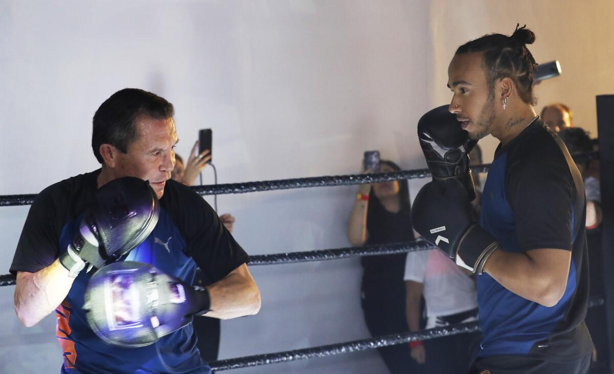 Mexican former boxing champion Julio Cesar Chavez, left, and British Mercedes driver Lewis Hamilton spar during a promotional event ahead of the Formula One race in Mexico City on Oct. 23.