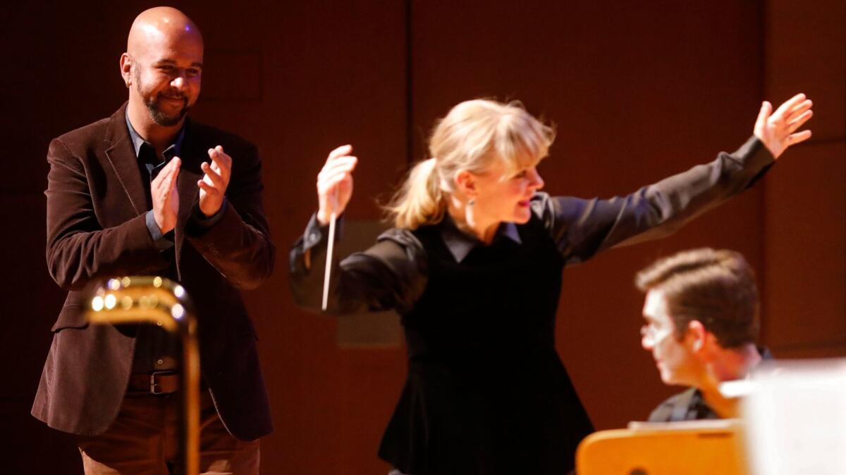 Composer Marcos Balter applauds conductor Susanna Mälkki during the curtain for premiere of "Things Fall Apart" with the L.A. Phil New Music Group at Walt Disney Concert Hall on Tuesday.