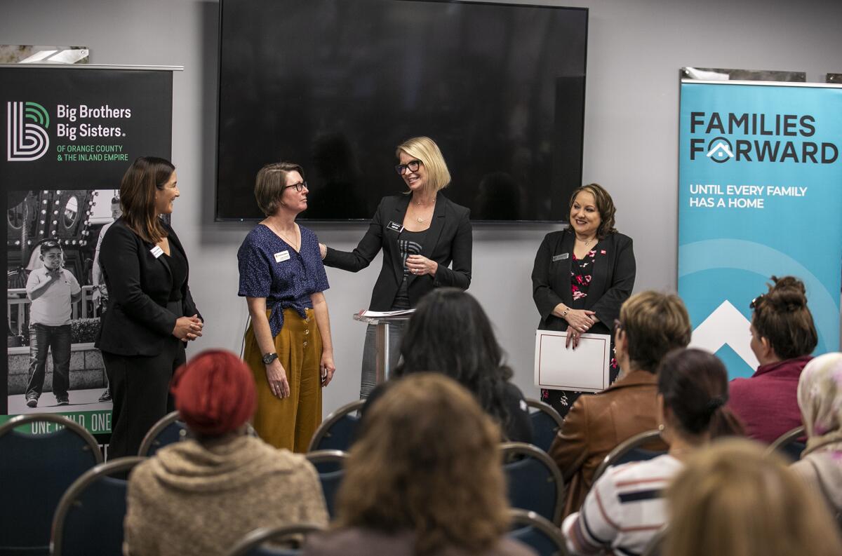 Madelynn Hirneise, left, Alison Edwards, Sloane Keane and Lucy Santana, address a crowd at the Santa Ana nonprofit hub.