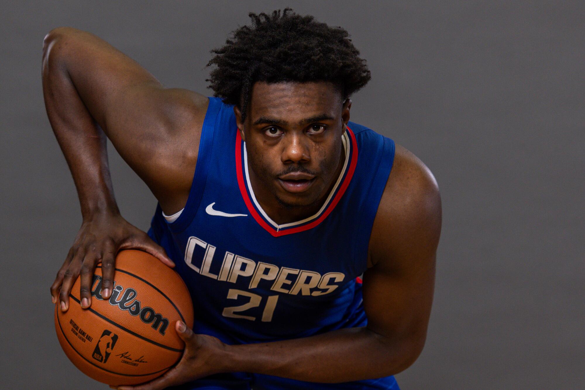 Clippers rookie forward Kobe Brown poses for a photo while holding a basketball.