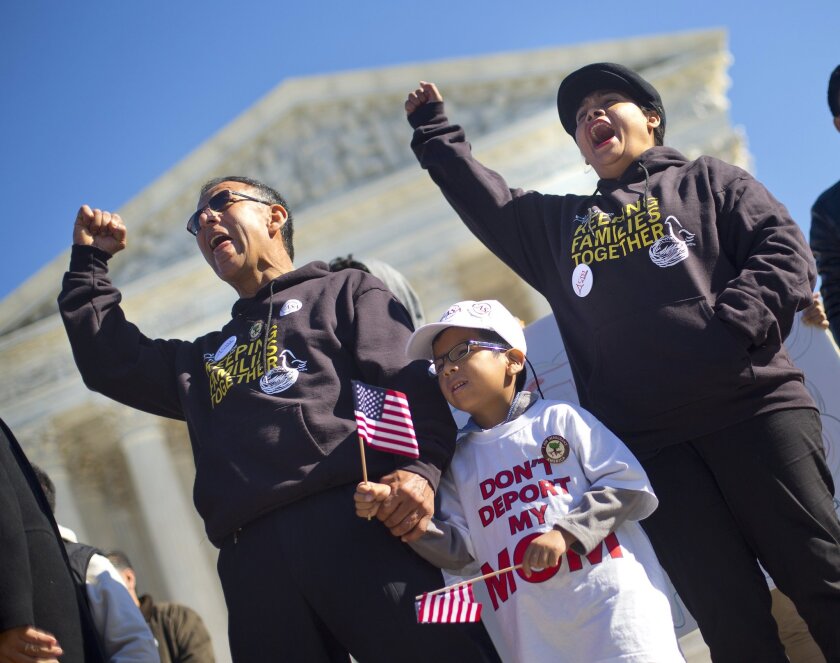 A six-year-old holds his father's hand during a rally for immigration reform in front of the Supreme Court on Nov. 20.