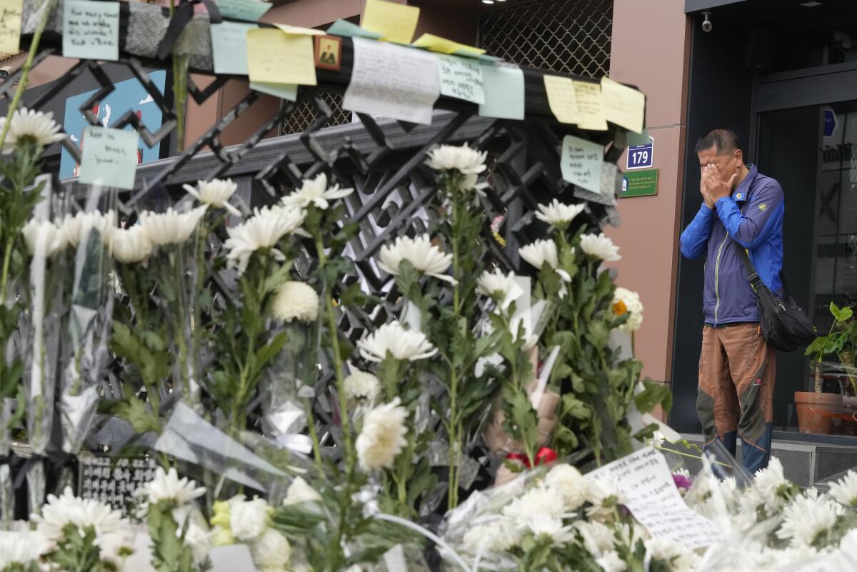 Man weeping next to floral tributes to crowd crush victims