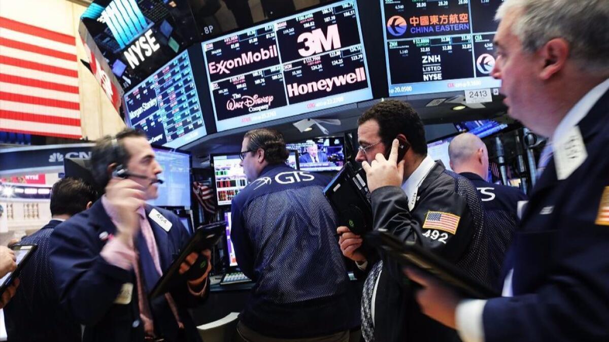 Traders work on the floor of the New York Stock Exchange as the Dow Jones industrial average set another record Friday.