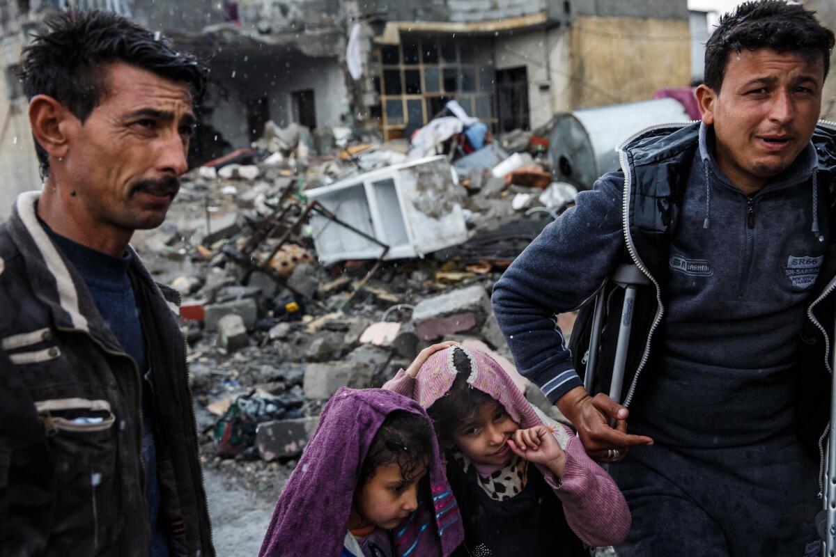 Adnan Ahmed Aaid, 25, right, surveys the remains of his former home which he said was destroyed in an airstrike in west Mosul on March 13. At left is his brother Shahab Ahmed Aiad, 40, with his daughters Imam Shahab Ahmed, 7, left, and Hijran Shahab Ahmed, 8.