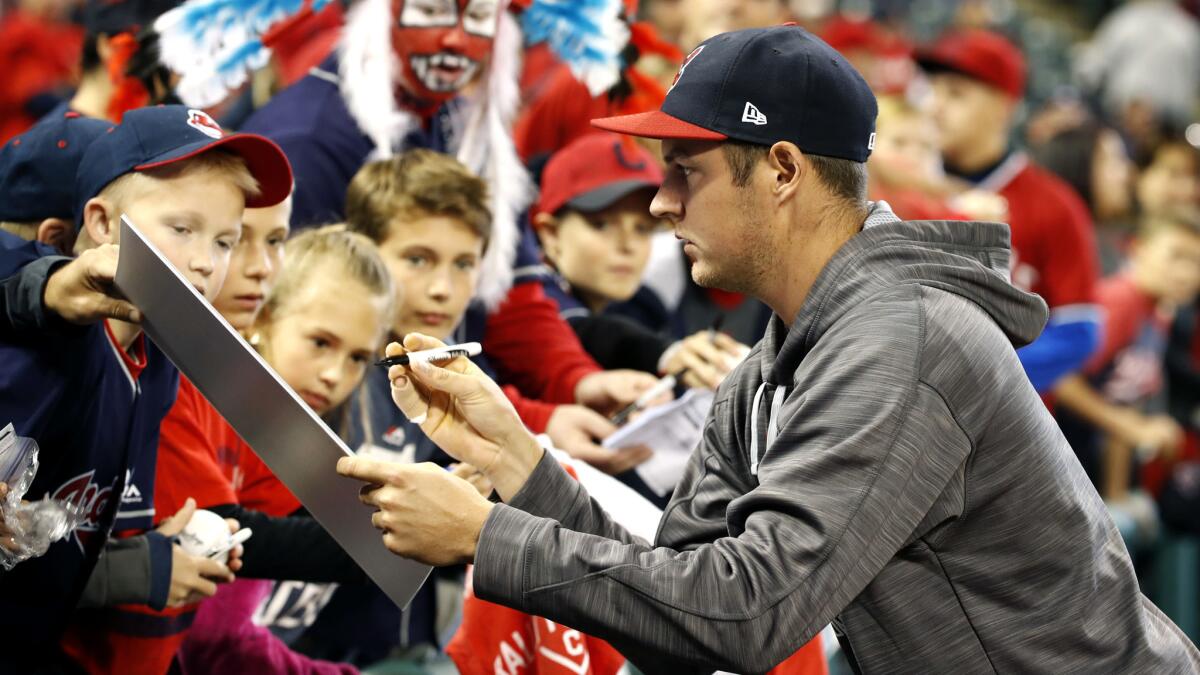 Indians pitcher Trevor Bauer wears a bandage on his right pinkie as he signs autographs before Game 1 of the ALCS in Cleveland.