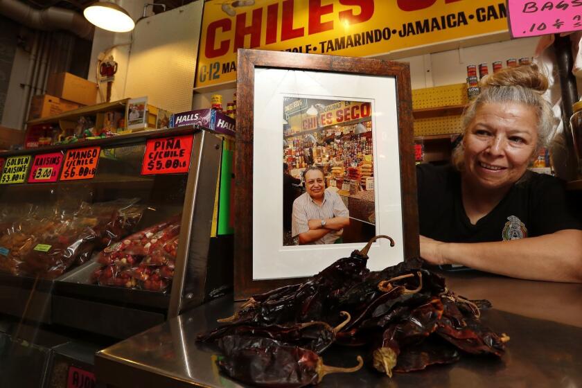 LOS ANGELES, CA-MARCH 22, 2018: Vendor Rocio Lopez, 58, is photographed next to a photograph of her father Celestine Lopez, at her stand located inside the Grand Central Market in downtown Los Angles on March 22, 2018. Celestino started the food stand back in the 1970's and Rocio took over the business after he passed away in 2008. (Mel Melcon/Los Angeles Times)