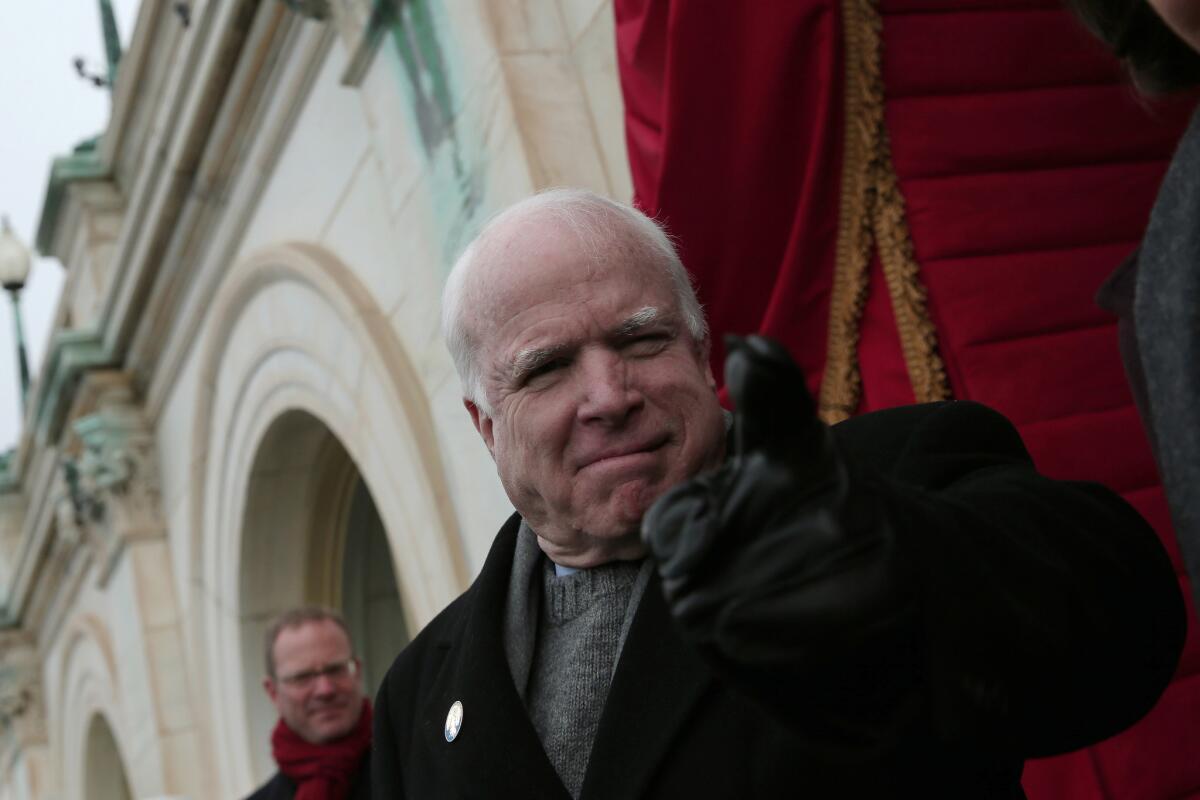 Senator John McCain (R-Ariz.) gestures to Rep. Peter King (R-N.Y.) before the presidential inauguration.