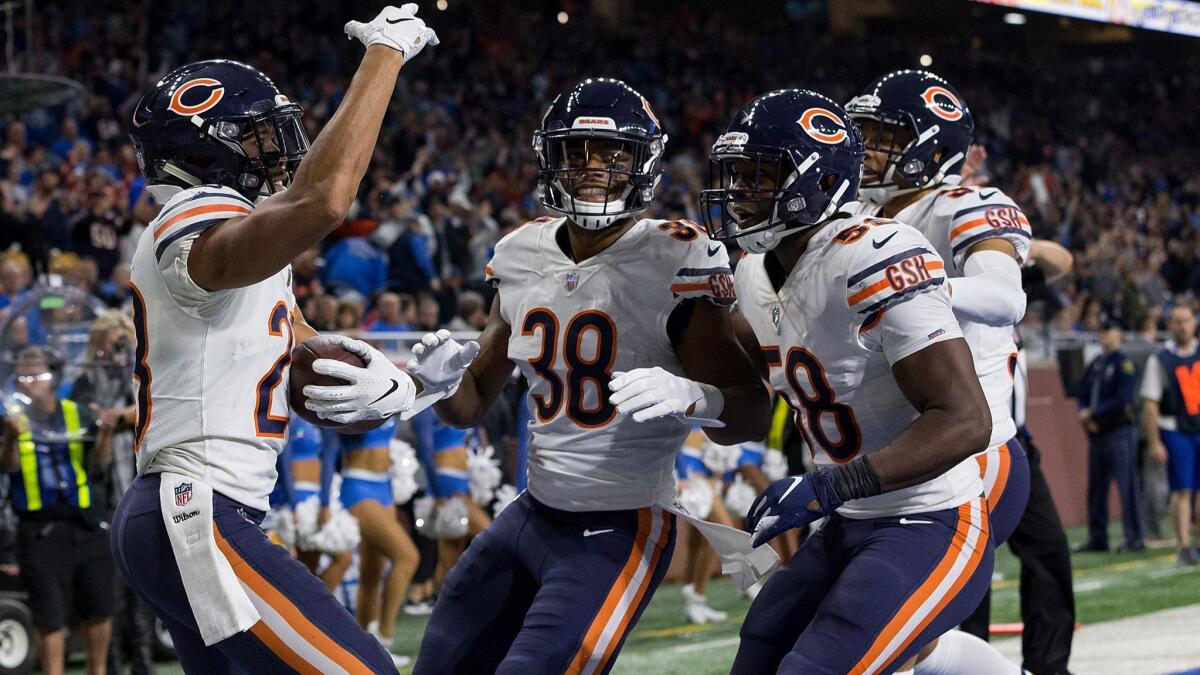 Bears cornerback Kyle Fuller, left, celebrates with teammates after intercepting a pass in the end zone to help seal the victory over the Lions on Thursday.