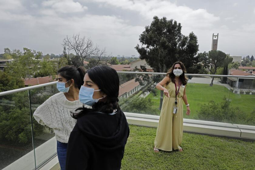 CLAREMONT, CA - APRIL 12: Lisa Ramapuram (cq), left, and her daughter Rhea Mistry, a senior at Riverside Polytechnic High School, take in the scenic view of Claremont McKenna College during a tour with Jennifer Sandoval-Dancs of the admission office. The school has reopened in-person tours after shutting them down last year amid the pandemic. The college tour is a key aid in helping students make their big decisions. Photographed at Claremont McKenna College on Monday, April 12, 2021 in Claremont, CA. (Myung J. Chun / Los Angeles Times)