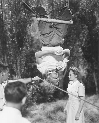 1948: Actor Van Johnson hangs from a trapeze with actress June Allyson on the ground on the set of director Norman Taurog's film "The Bride Goes Wild."