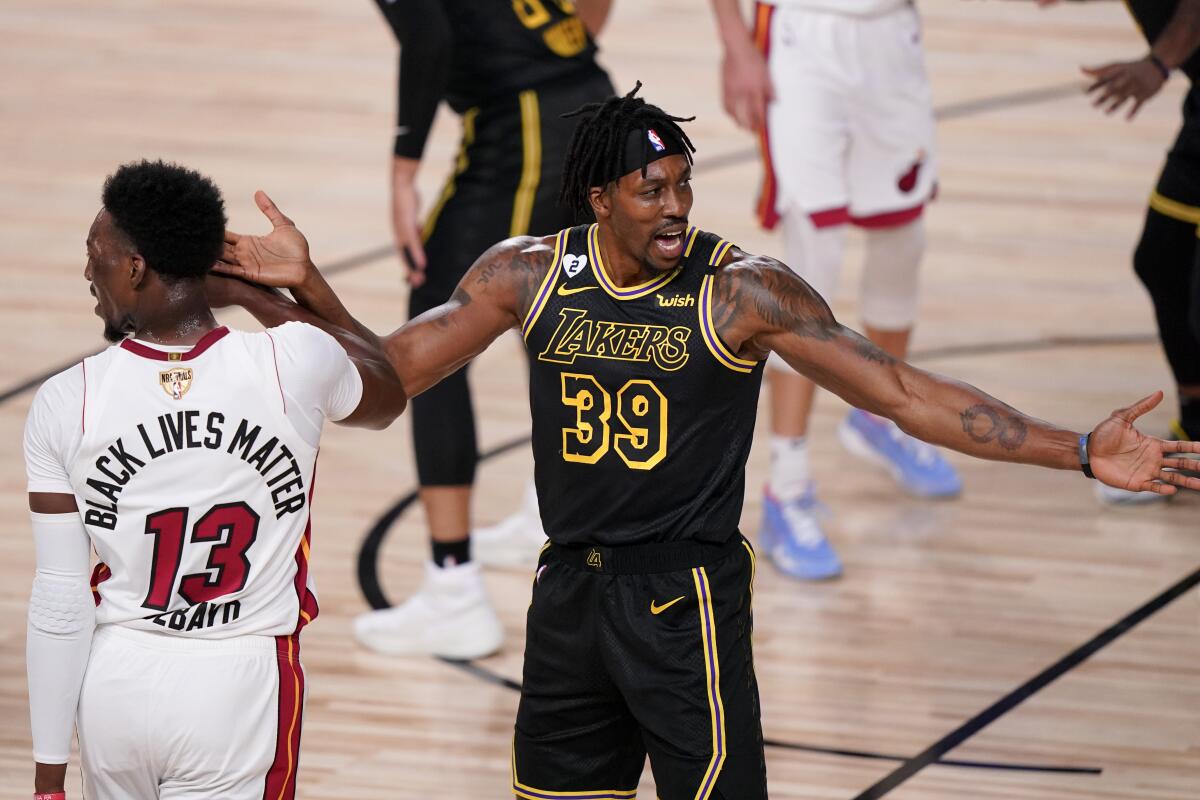 Lakers center Dwight Howard, right, reacts next to Miami Heat forward Bam Adebayo.