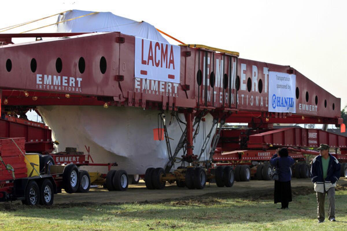 Miriam and Jose Ramos stop by to look at 340-ton boulder on its first stop in Glen Avon.The boulder is in its special made carrier and will go on display at the County Museum of Art by this summer.