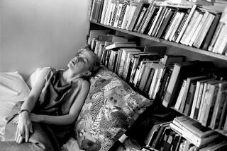 Acker lying next to her library in her Lower East Side loft in 1983.