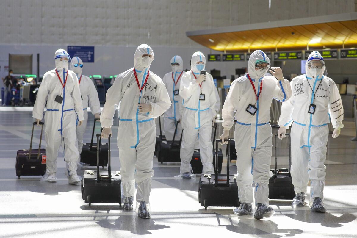 An airline flight crew wears protective gear at Los Angeles International Airport.