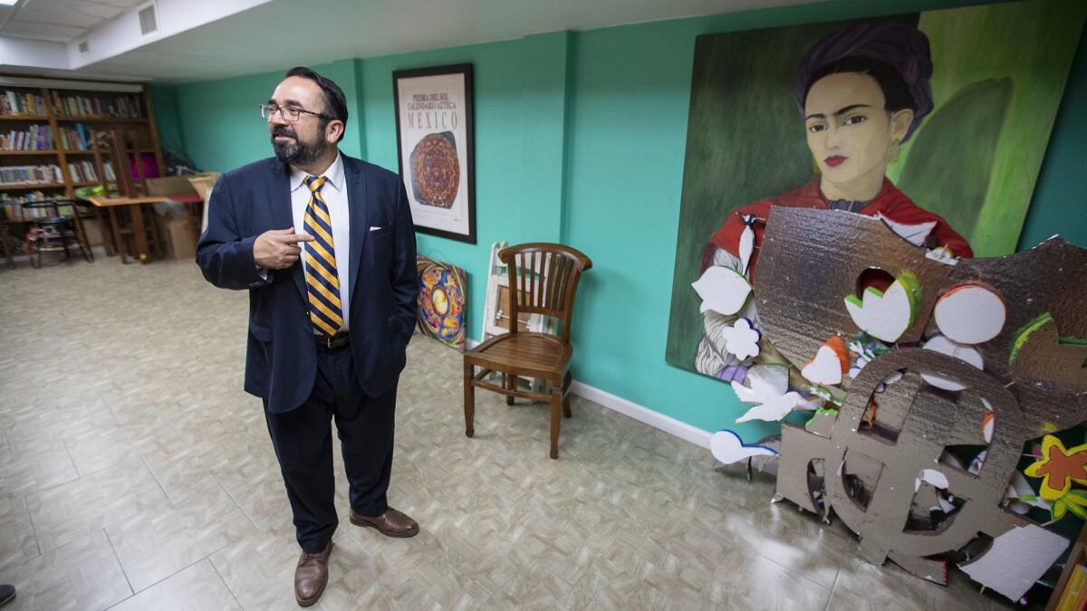 Ben Vazquez stands next to a painting of Frida Kahlo in the music room at El Centro Cultural de México in Santa Ana. Vazquez is a member of the center's board of directors.
