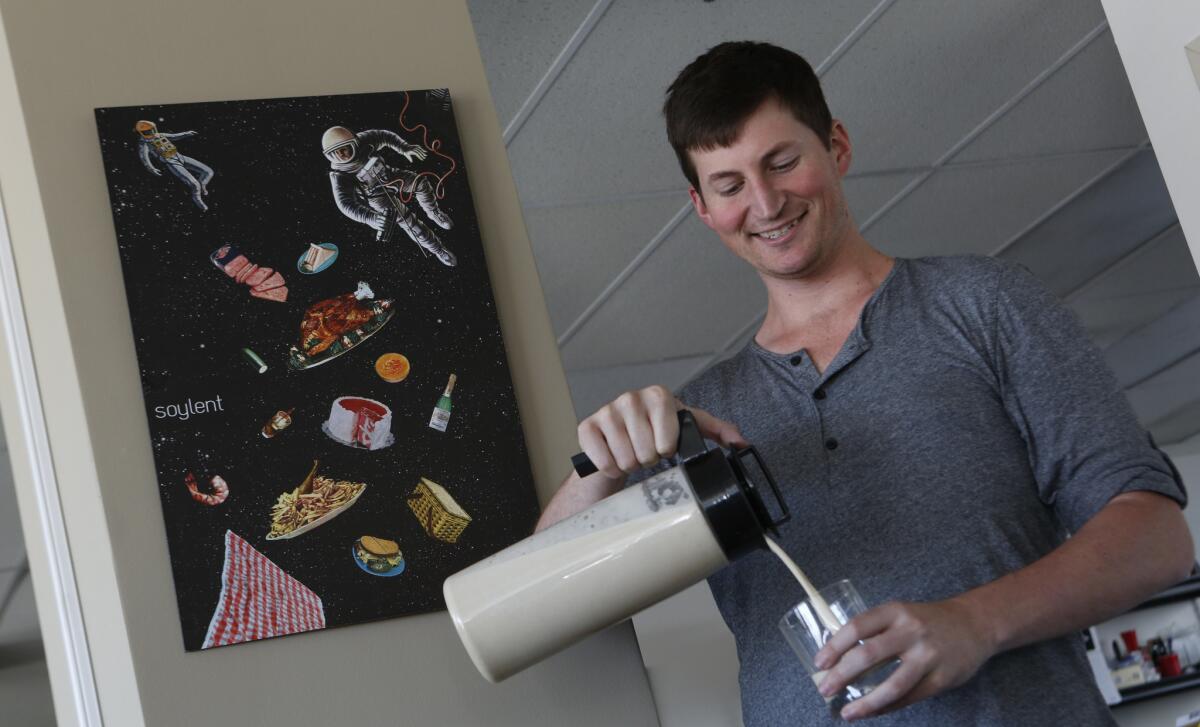 Soylent inventor and Chief Executive Rob Rhinehart pours a glass of the namesake drink at the company's offices in downtown Los Angeles. (Anne Cusack / Los Angeles Times)