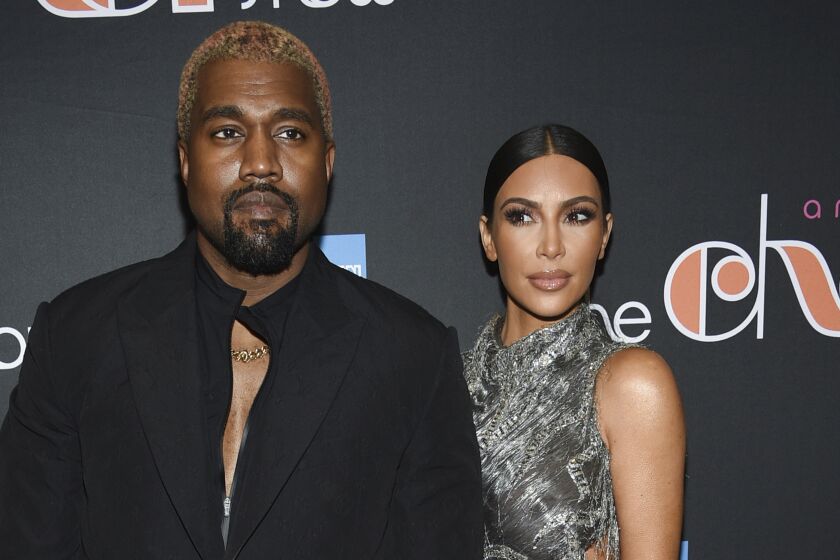 Kanye West posing alongside Kim Kardashian