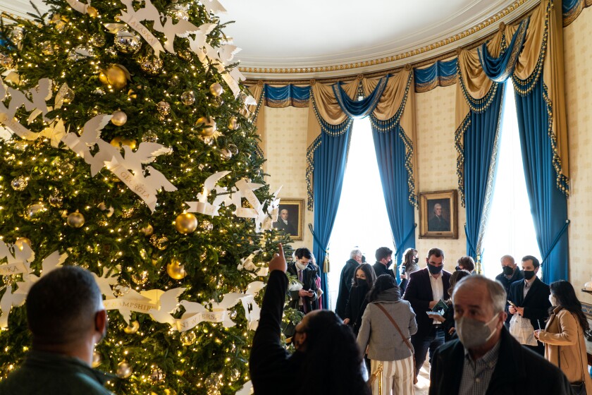WASHINGTON, DC - DECEMBER 23: In the Blue Room, members of the public look at the Official White House Christmas Tree, an eighteen and a half foot Fraser Fir from Jefferson, North Carolina as they tour the White House on Thursday, Dec. 23, 2021 in Washington, DC. Dating back to the Eisenhower Administration, a large Christmas tree has been consistently featured in the Blue Room. (Kent Nishimura / Los Angeles Times)