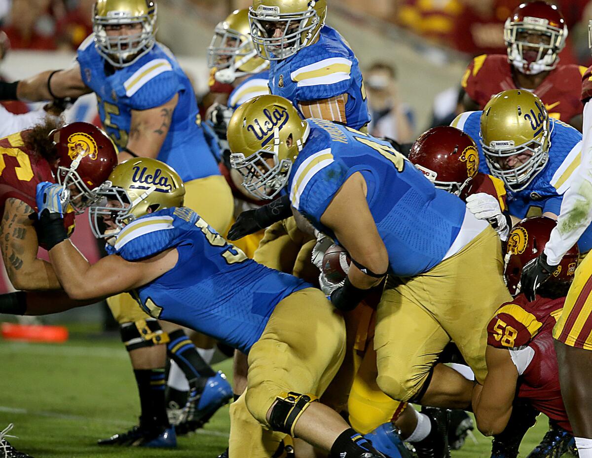 UCLA defensive tackle Eddie Vanderdoes runs the ball on offense for a touchdown against USC on Nov. 30, 2013.