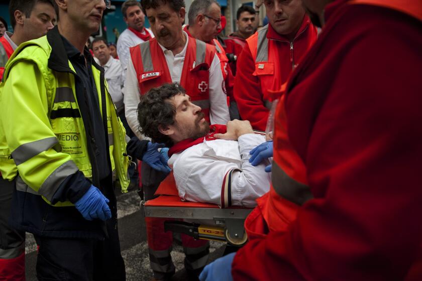 American author Bill Hillmann is carried on a stretcher after being gored in his right thigh during the running of the bulls in Pamplona, Spain, on Wednesday.