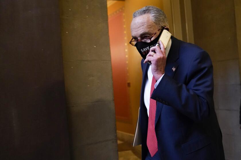 El líder de la minoría en el Senado, Chuck Schumer, habla por teléfono en el Capitolio el martes 15 de diciembre de 2020, en Washington. (AP Foto/Susan Walsh)