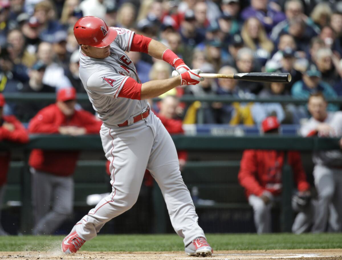 Mike Trout hits a home run in the first inning off of Seattle pitcher Felix Hernandez to give the Angels a 1-0 lead in their opening day game Monday against the Mariners.