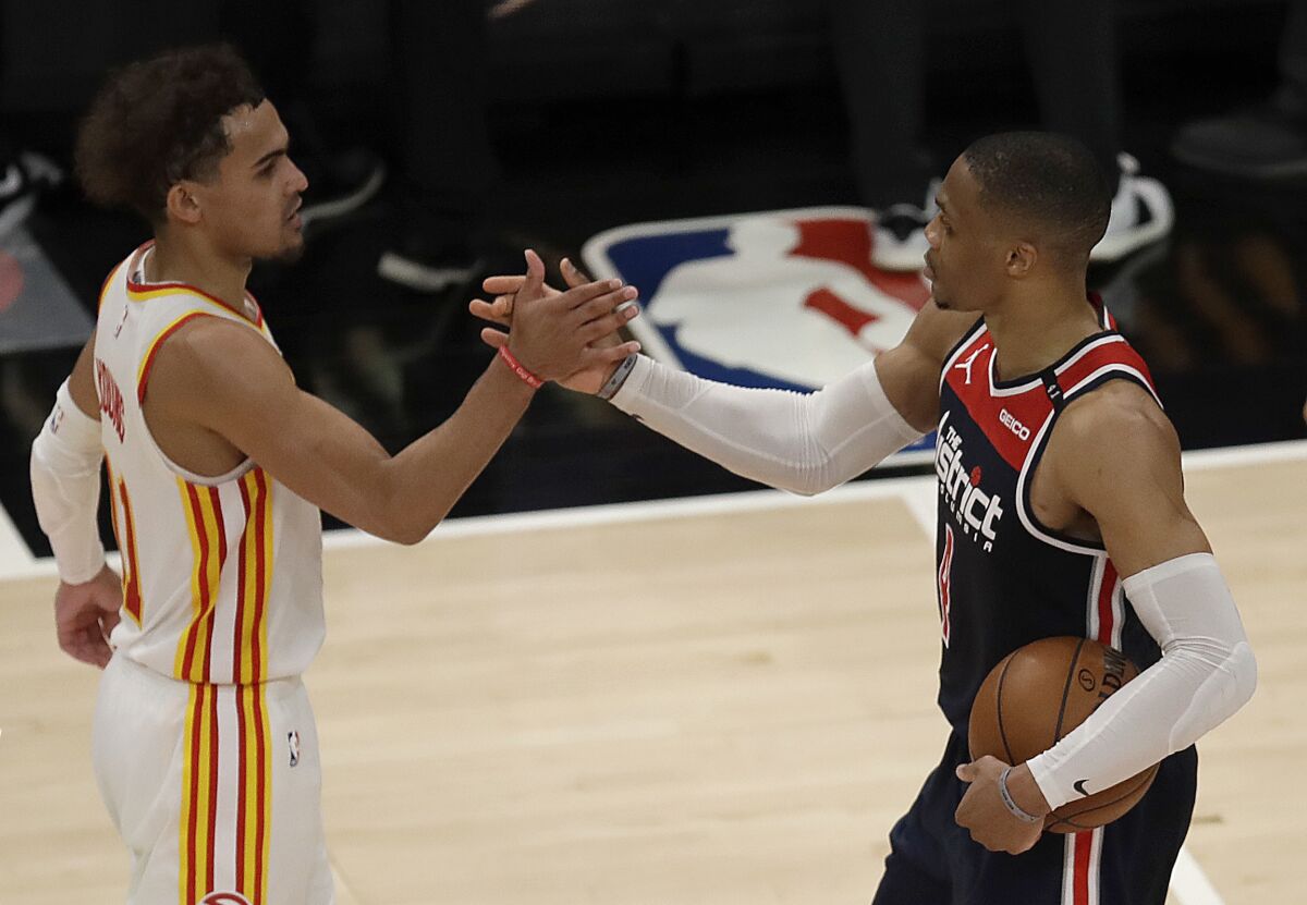 Washington Wizards' Russell Westbrook, right, is congratulated by Atlanta Hawks' Trae Young after an NBA basketball game Monday, May 10, 2021, in Atlanta. Westbrook recorded his 182nd career triple-double, passing Oscar Robertson for the most in NBA history. (AP Photo/Ben Margot)