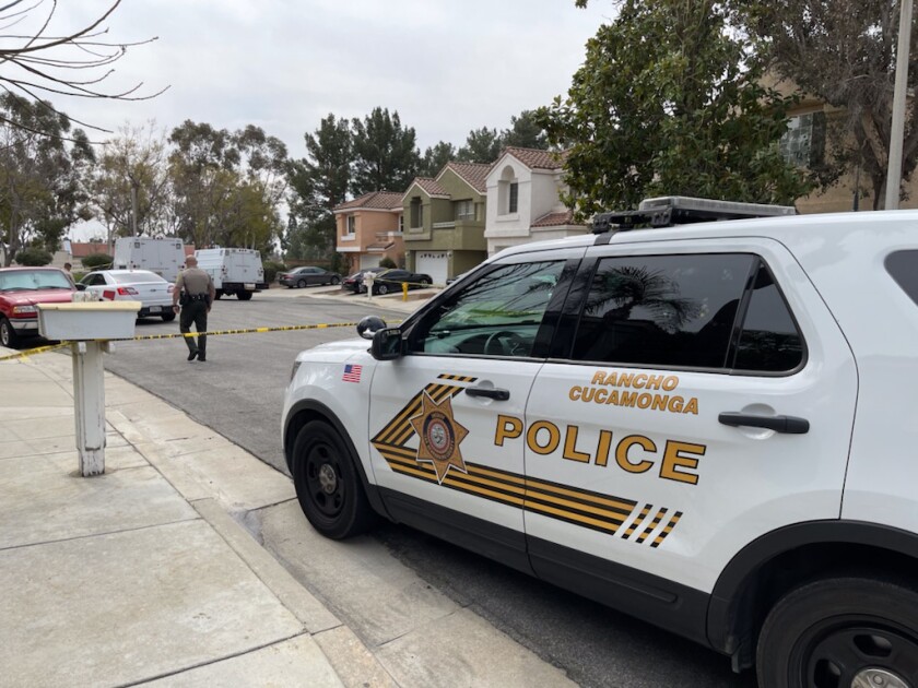 A police car is parked behind yellow tape blocking off a Rancho Cucamonga neighborhood. 