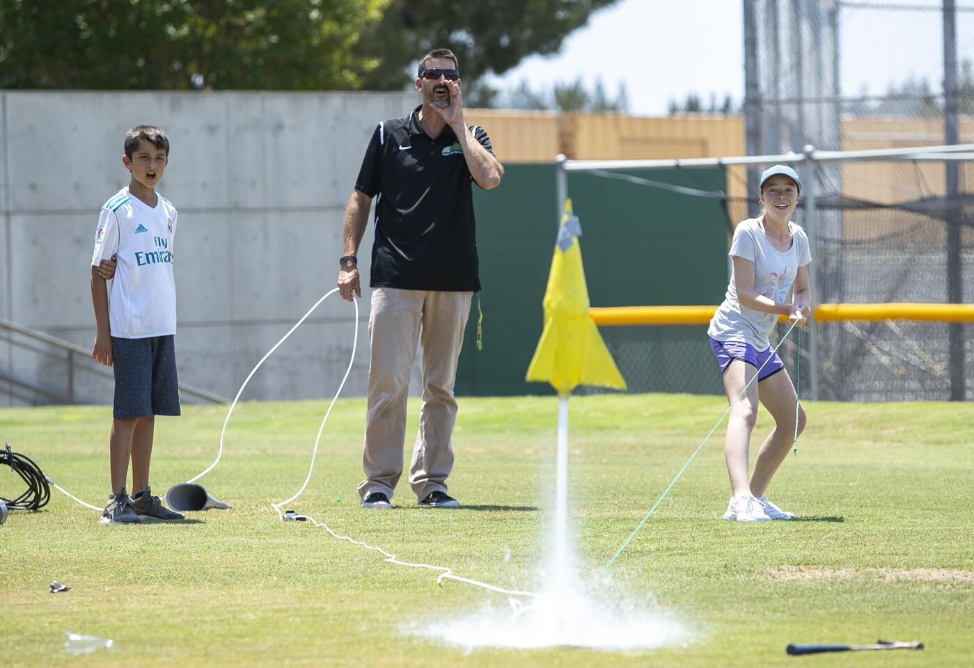 Sage Hill School chemistry teacher Kerry Langdale counts down as Kristina Vitale, 14, launches her plastic bottle rocket during Camp Sage, Sage Hill's summer day camp for middle-schoolers.