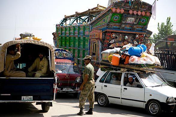 A soldier directs slow-moving traffic near Mardan, Pakistan.