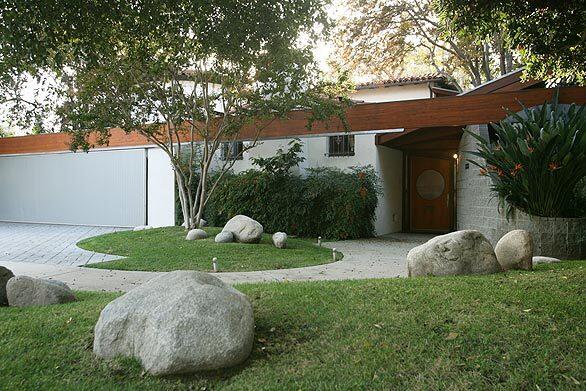 Architecture aficionados sometimes liken Bart Prince's soaring, layered residential designs to the work of John Lautner and Frank Lloyd Wright, but drive by one of his remodeling projects in South Pasadena, and you'd never suspect what hides behind the unassuming exterior. "The neighborhood preferred maintaining the general scale and appearance of the street side of the house, so I did little to change things there," Prince says. A single wooden beam provides some visual cohesion as it runs along the top of the garage and joins to the entrance way. The original second story is still visible above the Prince addition.