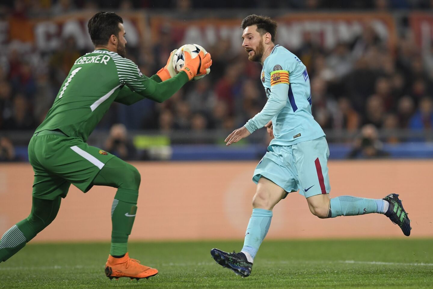 AS Roma's Brazilian goalkeeper Alisson Becker (L) catches the ball in front of FC Barcelona's Argentinian forward Lionel Messi (R) during the UEFA Champions League quarter-final second leg football match between AS Roma and FC Barcelona at the Olympic Stadium in Rome on April 10, 2018.