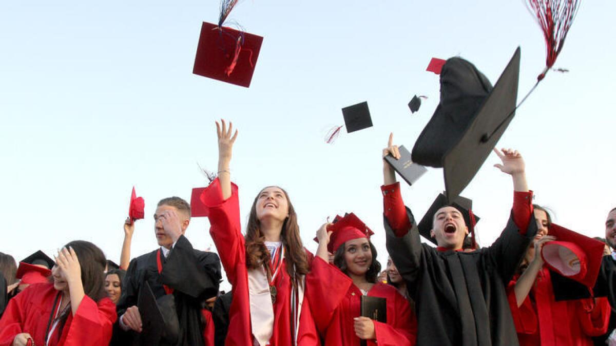Graduate Monica Agajanian, center, and others in her graduating class throw their caps up in the air at the end of the Glendale High School commencement ceremony on Wednesday, June 1, 2016.