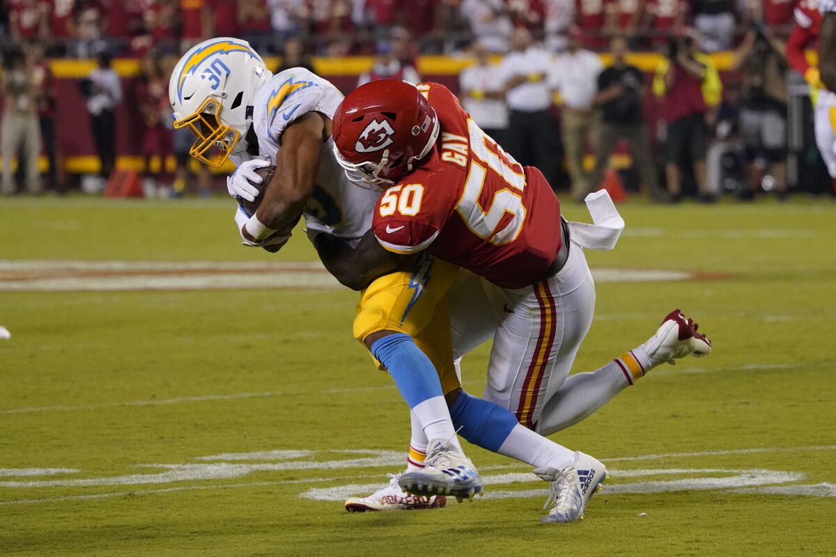 Chargers running back Austin Ekeler catches a pass as Kansas City Chiefs linebacker Willie Gay tackles him.