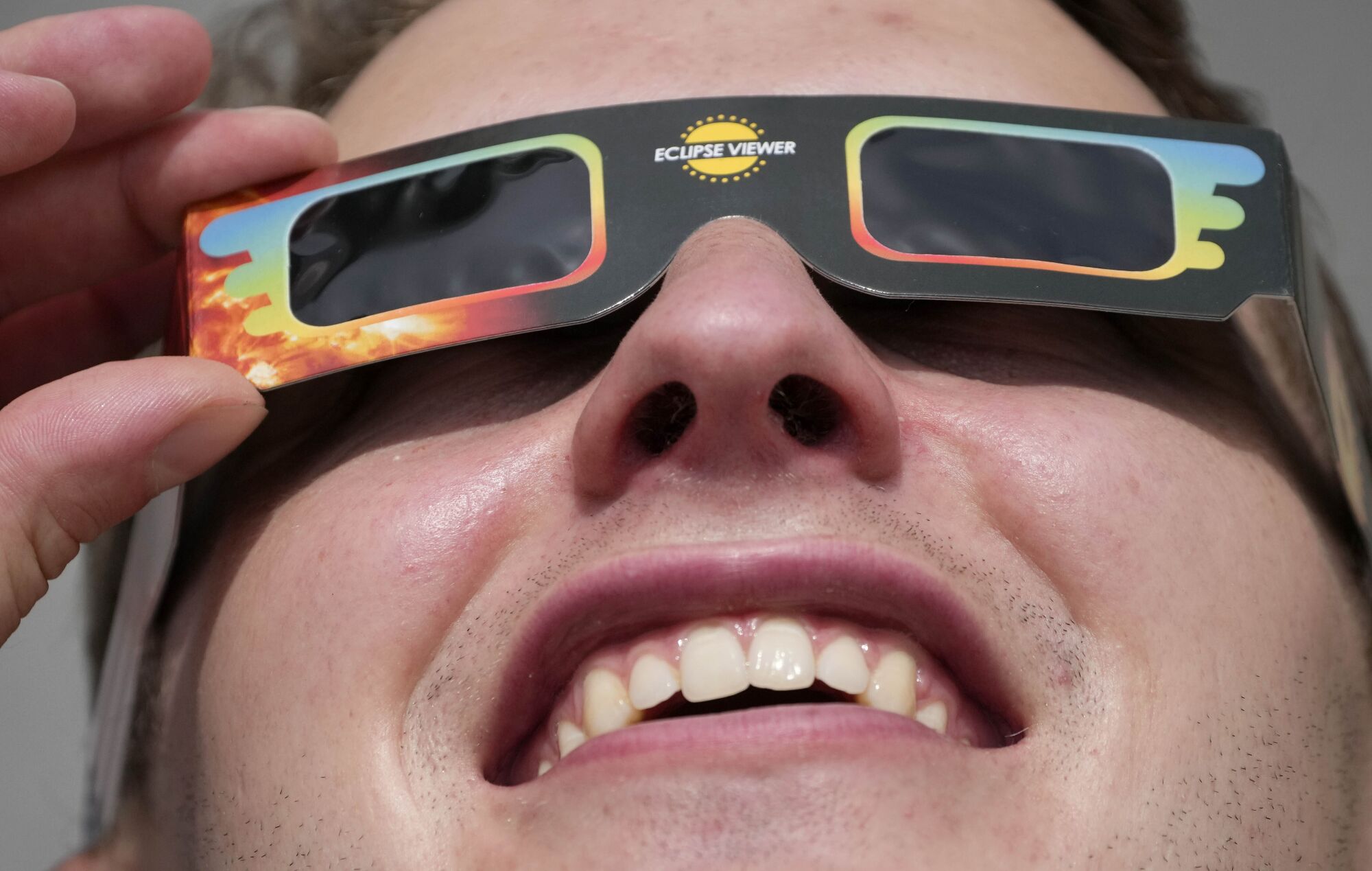 A man wears special glasses to watch the partial solar eclipse in Trafalgar Square in London.