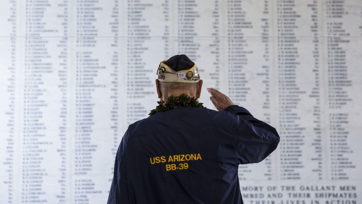 U.S.S. Arizona survivor Louis Conter salutes the remembrance wall of the U.S.S. Arizona during the 73rd anniversary of the attack on the U.S. naval base at Pearl harbor on Dec. 07, 2014.