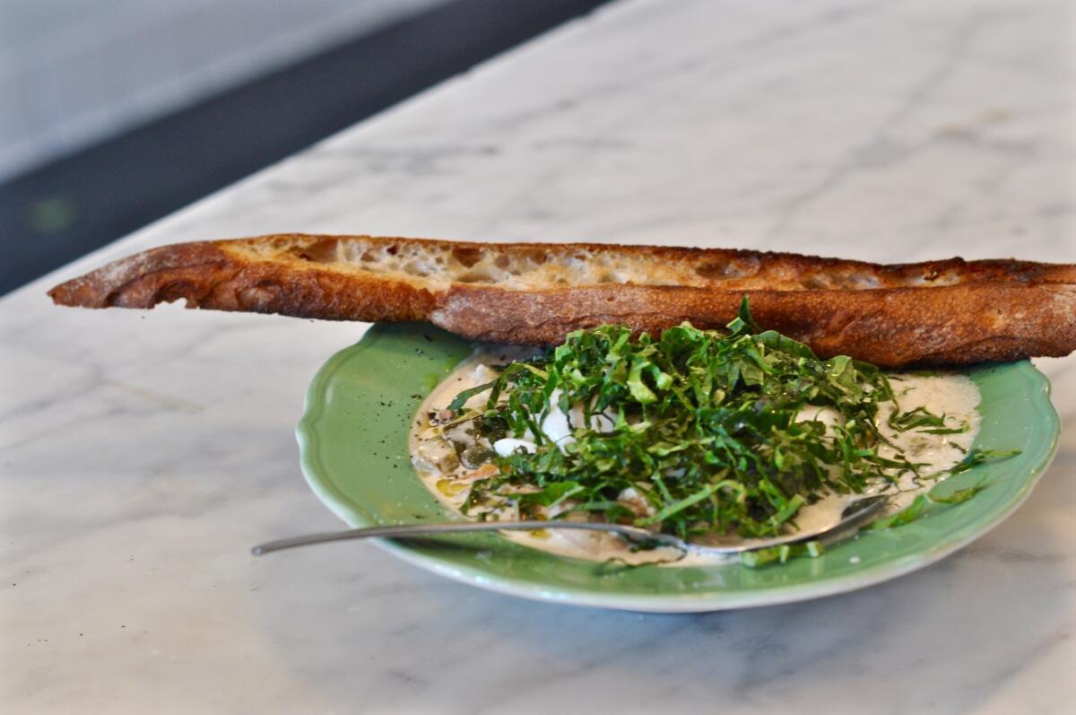 A bowl of black-eyed peas, with braised beans and celery, poached eggs, aioli, mustard greens and country toast.