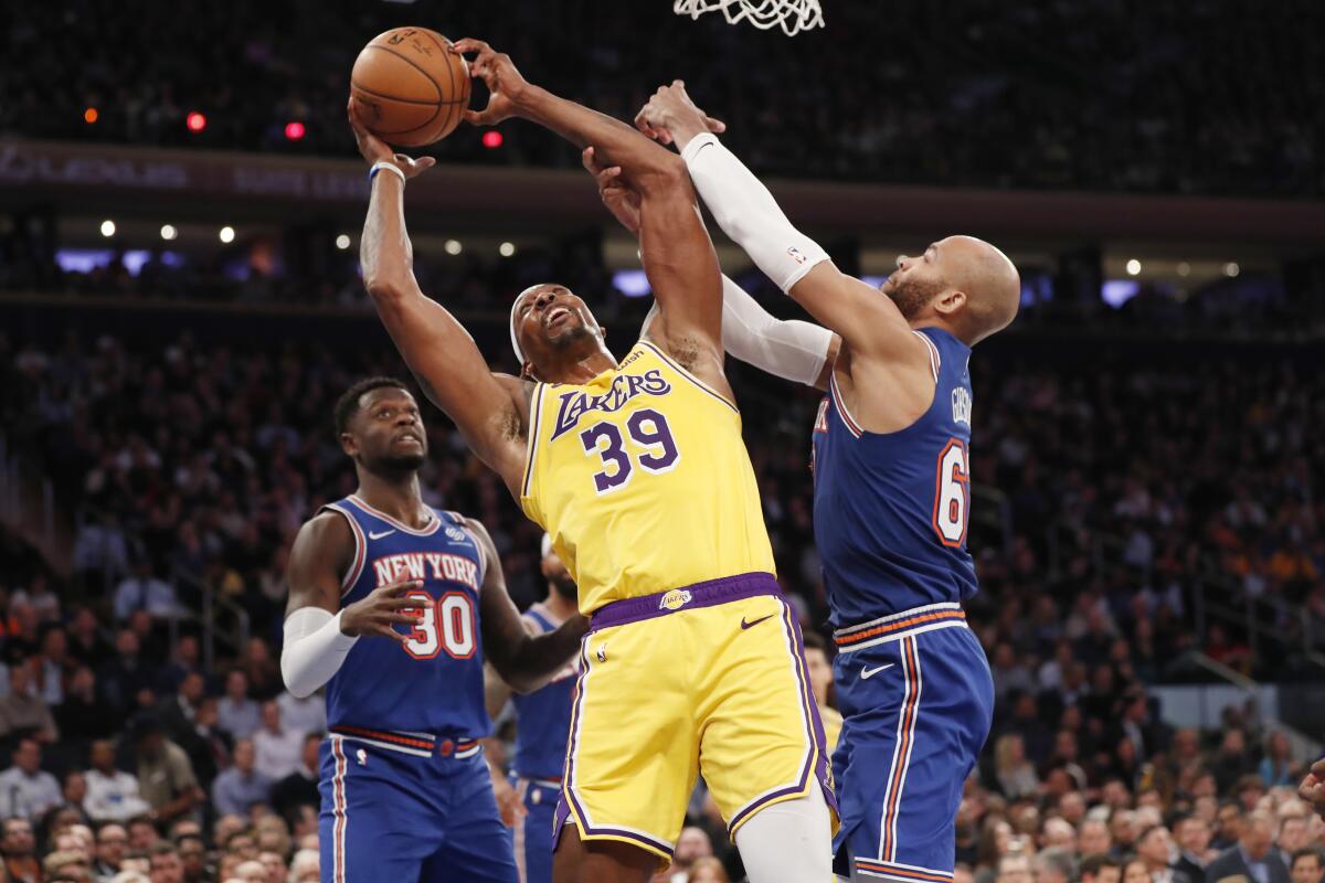 Lakers center Dwight Howard pulls down a rebound against Knicks forwards Taj Gibson, right, and Julius Randle during the first half of a game Jan. 22, 2020, in New York.