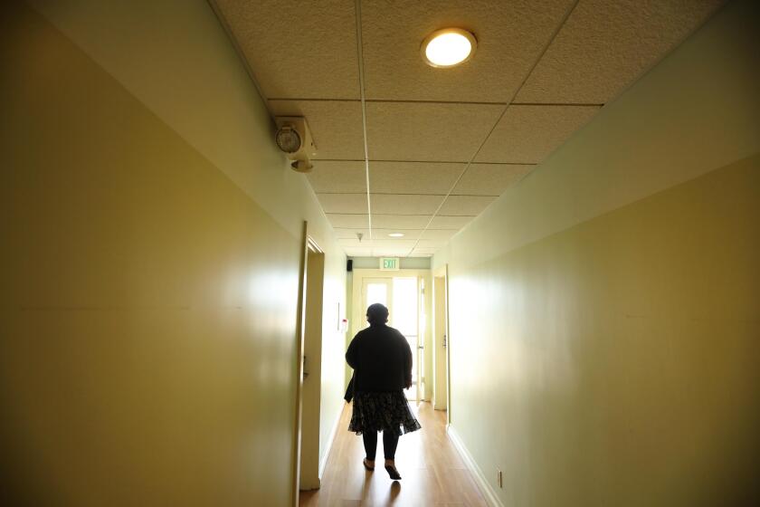 VENICE, CA - JUNE 1, 2020 - - Wendy Brown, 58, walks through the hallway where she now resides at the Cadillac Hotel in Venice on June 1, 2020. Brown spent three years sleeping on Venice sidewalks. Now as part of the Project Roomkey response to COVID-19 pandemic she is sleeping in a $240 a night room off the Venice boardwalk, taking daily runs and painting. But she wonders why the city before the pandemic offered homeless people everything but housing. Project Roomkey is a coordinated effort by the Los Angeles Homeless Services Authority to secure hotel and motel rooms in L.A. County as temporary shelters for people experiencing homelessness who are at high-risk for hospitalization if they contract COVID-19. (Genaro Molina / Los Angeles Times)