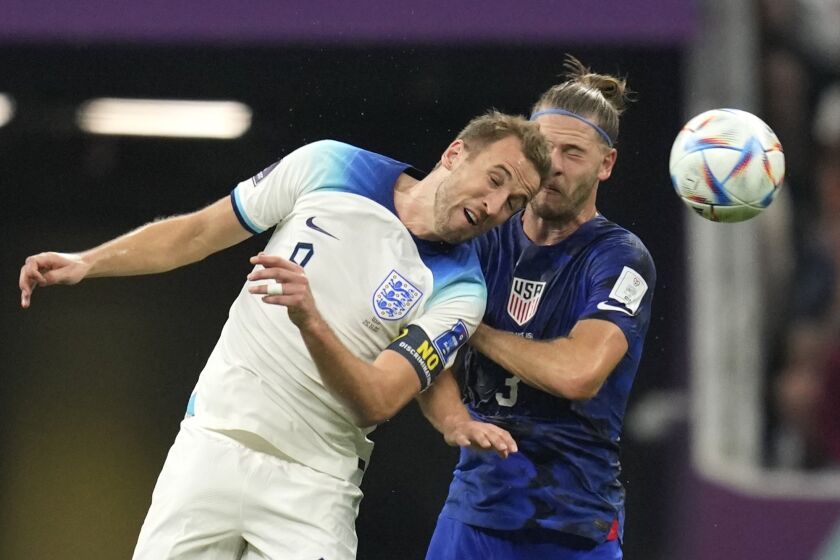 England's Harry Kane, left, challenges for the ball with Walker Zimmerman of the United States during the World Cup group B soccer match between England and The United States, at the Al Bayt Stadium in Al Khor, Qatar, Friday, Nov. 25, 2022. (AP Photo/Andre Penner)