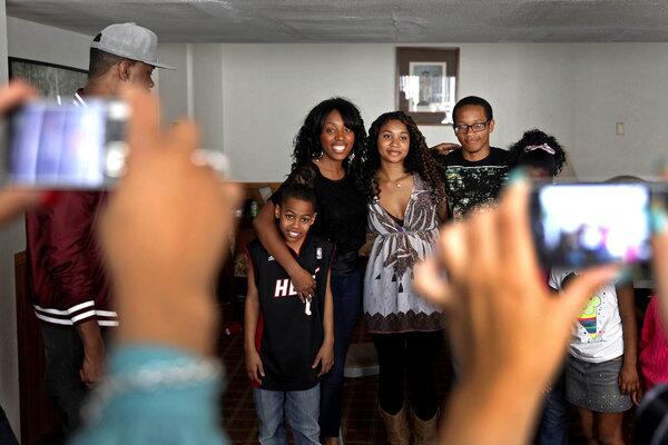 Meredith Kensington, center, in black top, poses with her nephew Nathan Robinson, 9, left, and her sister Marilyn, 19, right, and brother Aubrey Haynes, 18, far right, years after Marilyn and Aubrey were placed in adoption.